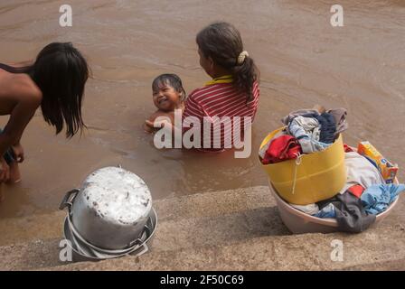 Darien Province, Panama. 07-18-2019. An indigenous grandmother is holding his grand son in the water. Stock Photo