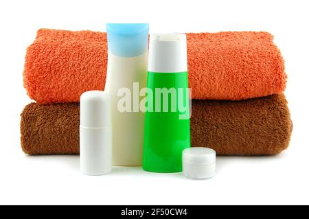 Cosmetic bottles with bath towels isolated on a white background Stock Photo