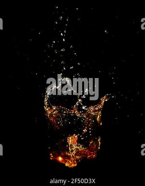 Whiskey splash isolated on black background. Stock Photo