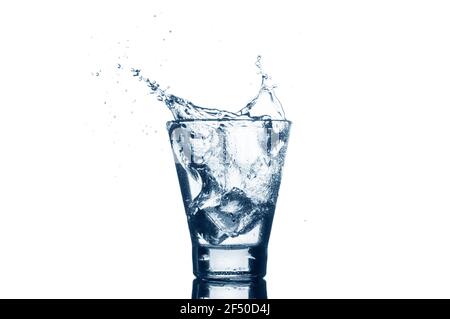 Water with splash and ice isolated on white background. Mineral water with ice in a glass. Stock Photo