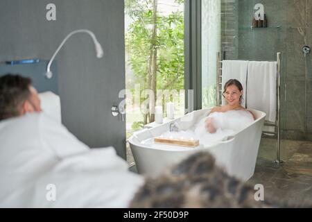Happy couple relaxing in luxury hotel room with soaking tub Stock Photo