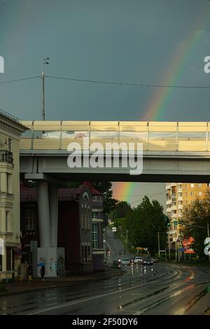 rainbow in the sky over the city after the rain. an old steam locomotive stands at the railway station Stock Photo