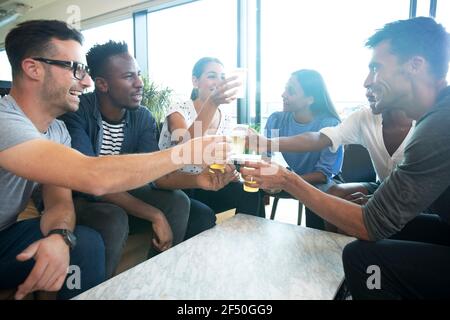 Diverse group of business people enjoying beers in office Stock Photo
