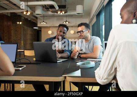 Businessmen meeting at laptop in office Stock Photo