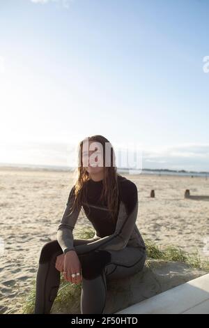 Portrait confident beautiful young female surfer in wet suit on beach Stock Photo