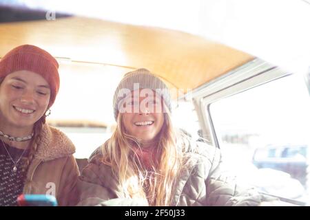 Portrait happy young women friends in sunny van Stock Photo