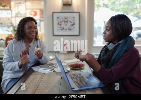 Businesswomen meeting at laptop in cafe Stock Photo