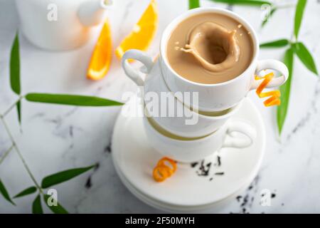 Earl grey milk tea poured in stacked cups Stock Photo
