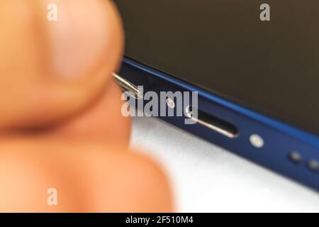 Kharkov, Ukraine - March 10, 2021: Apple iPhone repair concept, close up of small screw and charge connector Stock Photo
