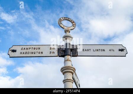 An old metal road sign post in Athelstaneford pointing towards Camptoun , Haddington and East Linton