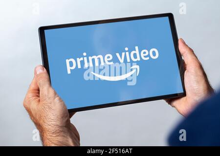 Man holding a tablet with prime video streaming service logo on the screen. Stock Photo