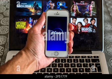 In this photo illustration the Disney+ app seen displayed on a smartphone screen and a Disney+ website displayed on laptop in the background. Stock Photo