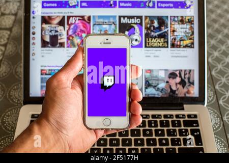 In this photo illustration the Twitch app seen displayed on a smartphone screen and a Twitch website displayed on laptop in the background. Stock Photo