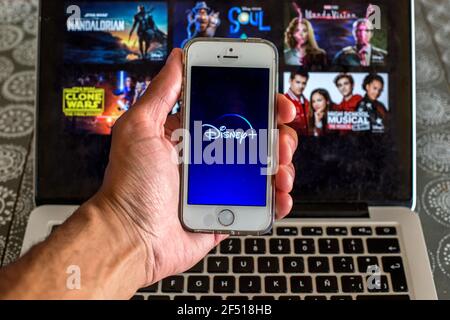 Barcelona, Catalonia, Spain. 23rd Mar, 2021. In this photo illustration the Disney  app seen displayed on a smartphone screen and a Disney  website displayed on laptop in the background. Credit: Thiago Prudencio/DAX/ZUMA Wire/Alamy Live News Stock Photo