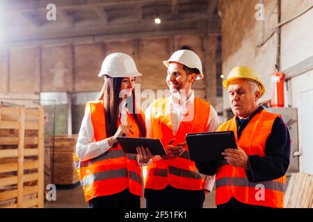 Group of engineers and workers discuss production plans Stock Photo