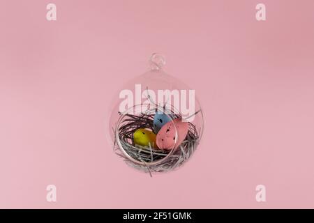 Three eggs in a floating glass nest. Pink background. Creative Easter concept Stock Photo