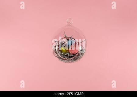 Three eggs in a floating glass nest. Pink background. Creative Easter concept Stock Photo