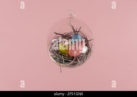 Three eggs in a floating glass nest. Pink background. Creative Easter concept Stock Photo