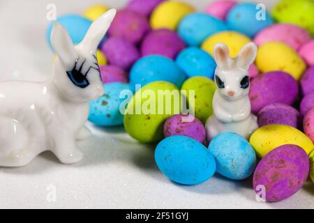 Bunnies With Speckled Candy Eggs On Snowy White Stock Photo