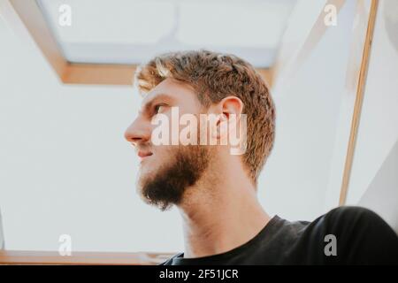 Portrait of a handsome man with blond hair looking away under the sunlight Stock Photo