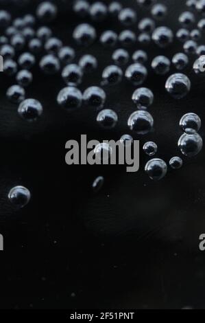 Close-up of gas bubbles in water. Soda water on close-up. Carbonated water on a dark background. Background with bubbles of carbonated water. Stock Photo