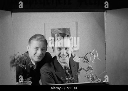 To the optical axis. Portrait series, perhaps by participants on a course, in a window box. View with two young men Stock Photo