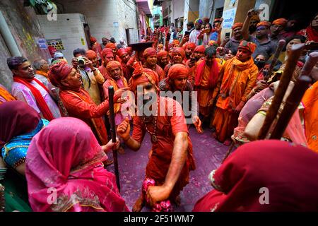 Mathura, India. 23rd Mar, 2021. Devotees dancing during the Lathmar Holi Festival of Barsana.The myth behind this festival is related to Hindu God Lord Krishna who as per local belief came from his hometown Nandgaon to Barsana to tease Radha (a Hindu goddess and a consort of the god Krishna) and her friends. For more than 100 years, women of Barsana still maintaining the ritual. (Photo by Avishek Das/SOPA Images/Sipa USA) Credit: Sipa USA/Alamy Live News Stock Photo