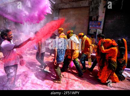 Mathura, India. 23rd Mar, 2021. Devotees seen throwing colourful powder at colleagues during the Lathmar Holi Festival of Barsana.The myth behind this festival is related to Hindu God Lord Krishna who as per local belief came from his hometown Nandgaon to Barsana to tease Radha (a Hindu goddess and a consort of the god Krishna) and her friends. For more than 100 years, women of Barsana still maintaining the ritual. (Photo by Avishek Das/SOPA Images/Sipa USA) Credit: Sipa USA/Alamy Live News Stock Photo