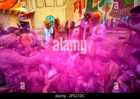 Mathura, India. 23rd Mar, 2021. Devotees throwing colours at each other during the Lathmar Holi Festival of Barsana.The myth behind this festival is related to Hindu God Lord Krishna who as per local belief came from his hometown Nandgaon to Barsana to tease Radha (a Hindu goddess and a consort of the god Krishna) and her friends. For more than 100 years, women of Barsana still maintaining the ritual. Credit: SOPA Images Limited/Alamy Live News Stock Photo