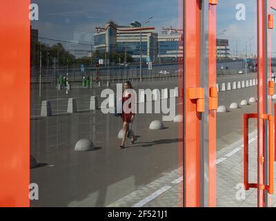 Moscow, Russia. 6th Sep, 2020. A woman in a red sundress is reflected in the glass of the doors with the red frames of the Russian Railways Arena. Credit: Mihail Tokmakov/SOPA Images/ZUMA Wire/Alamy Live News Stock Photo