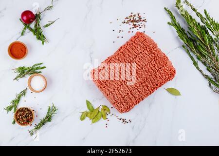 Raw ground beef with spices and rosemary on white background. Stock Photo