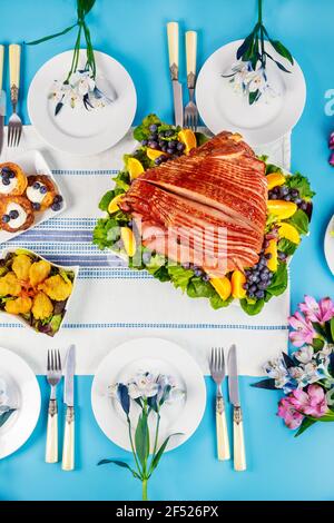 Spiral sliced glazed ham on festive Easter table. Holiday concept. Stock Photo