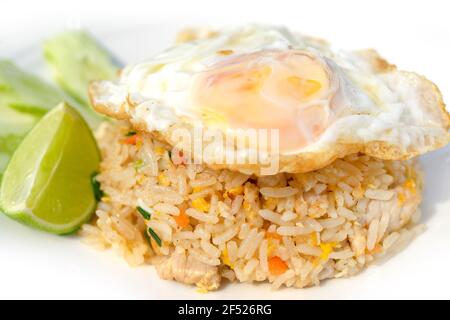 Closed up on delicious fried rice with pork or chicken and vegetables topping with fried egg Stock Photo