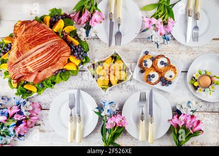 Table setting with baked pork ham on Easter table. Holiday concept. Stock Photo