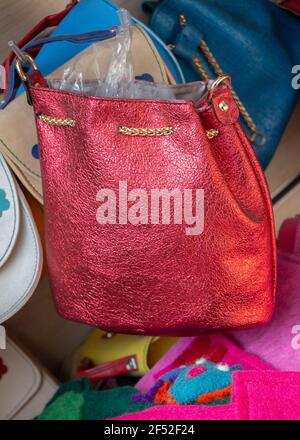 Vertical shot of a bright red bag displayed in a store Stock Photo