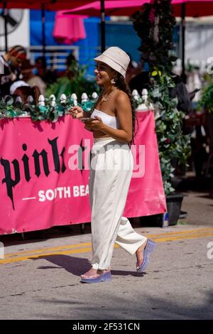 Beautiful young woman walking in Miami Beach to meet friends for spring break Stock Photo