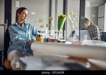 Smiling cute young woman focused on her work Stock Photo