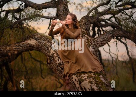 Redhead woman in dress walking in fantasy fairy tale forest Stock Photo