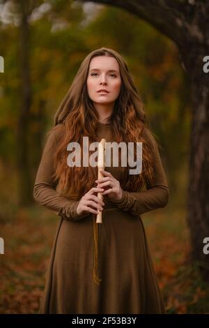 Redhead woman in dress walking in fantasy fairy tale forest Stock Photo