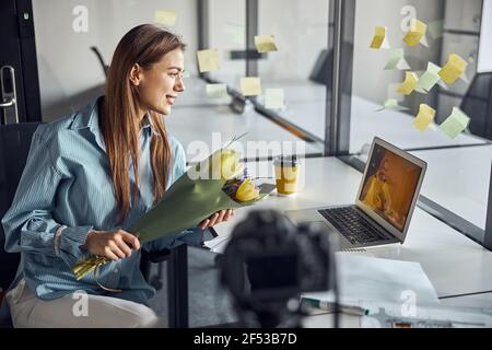 Pleased woman employee communicating with her boyfriend online Stock Photo
