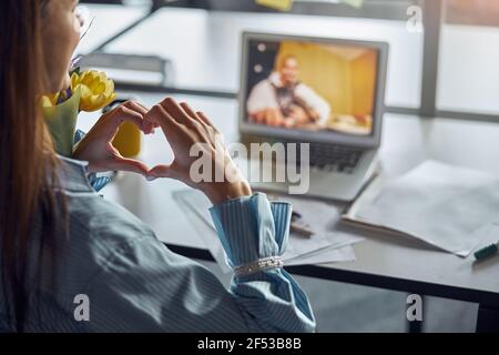 Dark-haired female office employee demonstrating love for her boyfriend Stock Photo