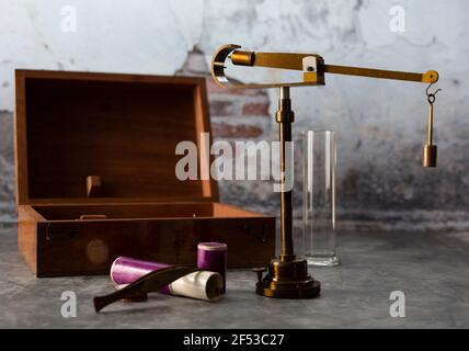 Old vintage pharmaceutical scale measuring  the weight  with old wall as background.. Stock Photo