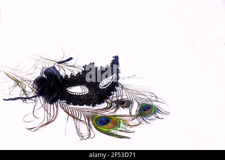 A fancy black venetian mask with lace and diamantes with peacock feathers for carnival and fasching isolated on a white background. Stock Photo