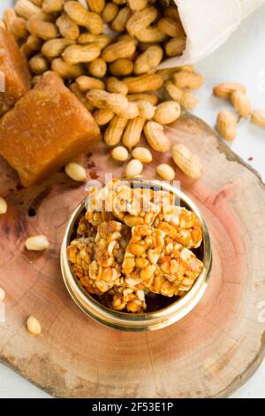 Peanut bar,crunchy sweet peanut bar which is very healthy and tasty snack,arranged in a brass vessel with some  peanut and jaggery in the background, Stock Photo