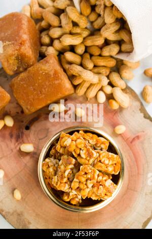 Peanut bar,crunchy sweet peanut bar which is very healthy and tasty snack,arranged in a brass vessel with some  peanut and jaggery in the background, Stock Photo