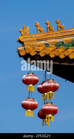 Many Chinese lanterns and gods on Roof top of Chinese houses against blue sky. Stock Photo