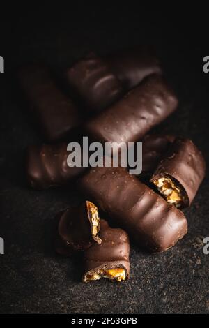 Chocolate bars with nuts filling on black table. Stock Photo