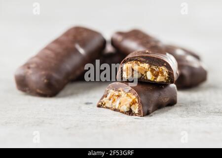 Chocolate bars with nuts filling on white table. Stock Photo