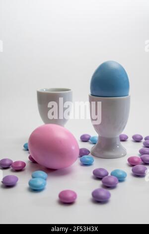 Side view of  porcelain Easter bunnies Porcelain Egg Cups with Pink Easter egg.On a white background . Stock Photo