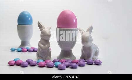 Side view of  porcelain Easter bunnies Porcelain Egg Cups with Pink Easter egg.On a white background . Stock Photo